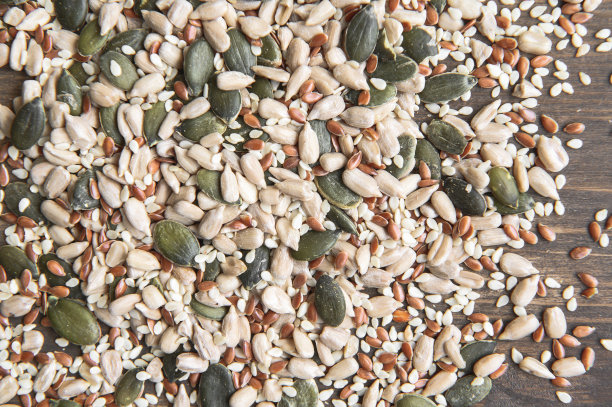 亚麻籽，葵花籽，南瓜籽，芝麻籽在木制的背景上。前视图。选择对焦的照片。图片下载