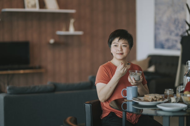 一位中年妇女在她的公寓里享受她的早餐图片下载