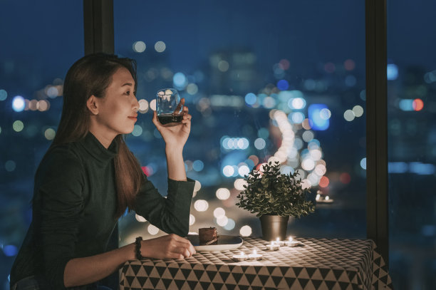 一个亚洲中国美丽的年轻女士在她的公寓在魔术小时，黄昏放松和享受时刻图片下载