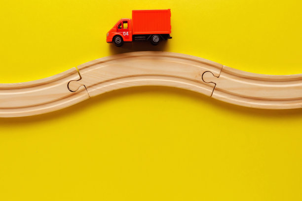 儿童玩具框架在黄色背景，玩具木制铁路和火车。前视图。Flatlay。文本复制空间图片下载