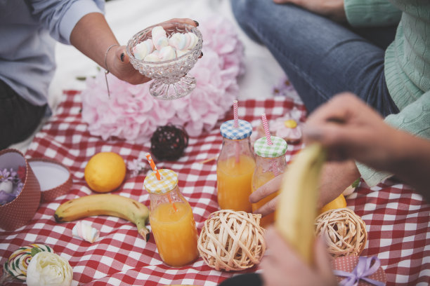 妇女们在野餐时吃水果、糖果和橙汁图片下载