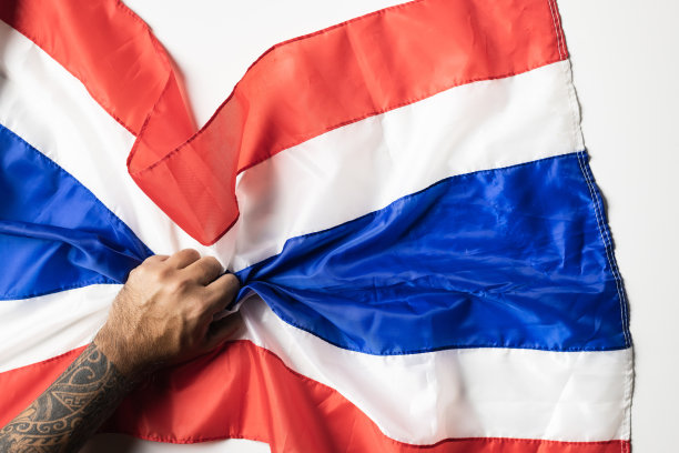 男人的手与纹身持有泰国国旗皱在白色的背景为拷贝空间。图片下载