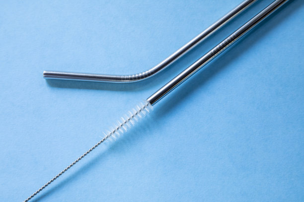 可重复使用的不锈钢吸管和清洁刷，蓝色背景，生态友好的生活方式，拷贝空间，俯视图，平面布局。图片下载