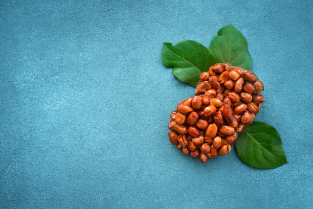 由花生、蜂蜜和蓝色背景上的天然树枝制成的美味的东方糖果。图片下载