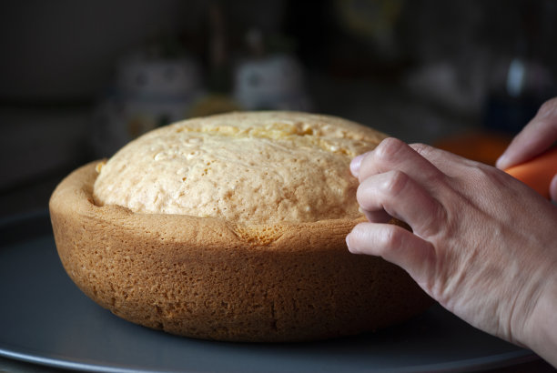 妇女的双手正在切割美味的手工蛋糕，新冠肺炎大流行期间制作的食物图片下载