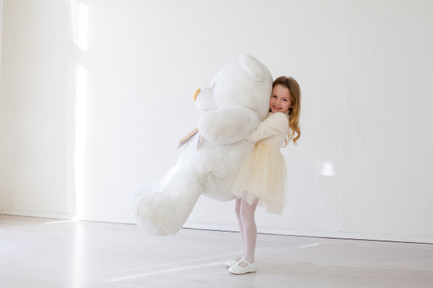 漂亮的小女孩和玩具大泰迪熊图片下载