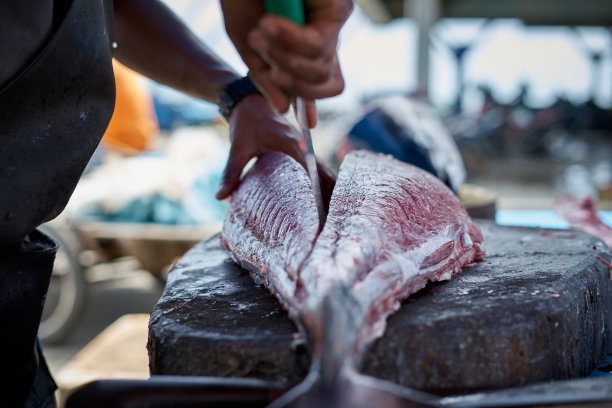 新鲜的大金枪鱼被海鲜小贩在鱼市切图片下载