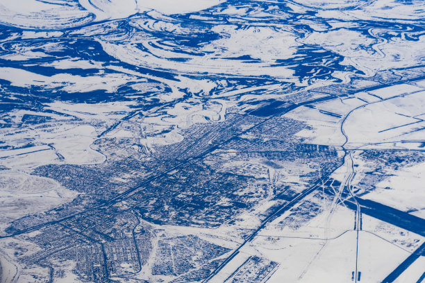 这是俄罗斯西伯利亚雪地里的城市和道路的航拍照片图片下载