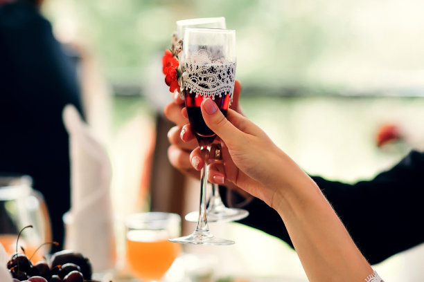 在婚礼上手持红色香槟酒杯的新娘和新郎图片下载