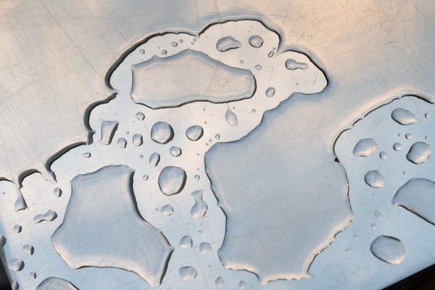 在下雨后的金属表面上的具有粘性的水滴的抽象特写图片下载