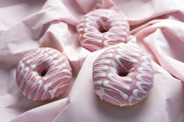粉色釉面装饰甜甜圈在波浪粉色背景上的各种焦点图片下载