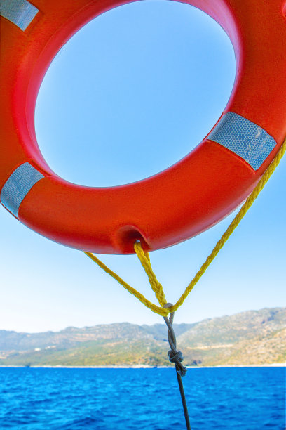 蓝色天空背景上的橙色救生圈。图片下载