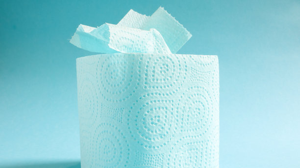 蓝色背景上的蓝色现代卫生纸卷。一种贴在纸板套上的纸产品，用于卫生目的，由纤维素制成，带有易于撕裂的切口。压花画图片下载