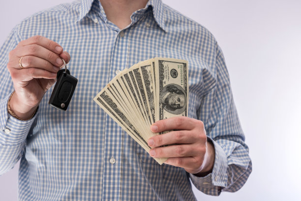 商人拿着车钥匙和美元钱被隔离图片下载
