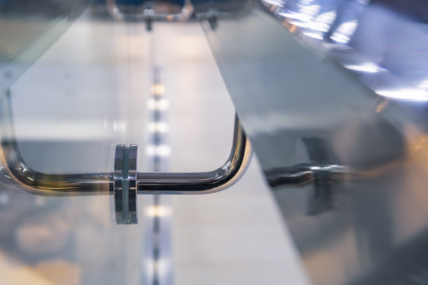 不锈钢扶手支撑，反射和玻璃墙在现代建筑。特写镜头。现代设计。有选择性的重点。图片下载