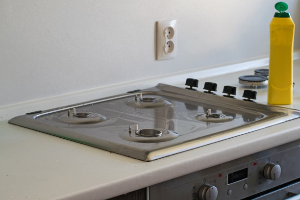 打扫厨房。用清洁剂清洗煤气炉。图片下载