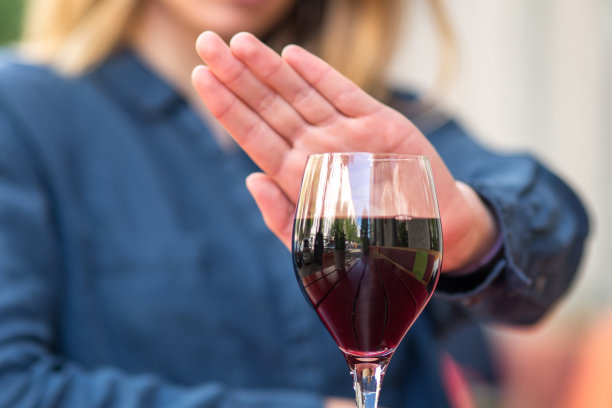 用手势拒绝喝葡萄酒或酒精饮料的女性。图片下载