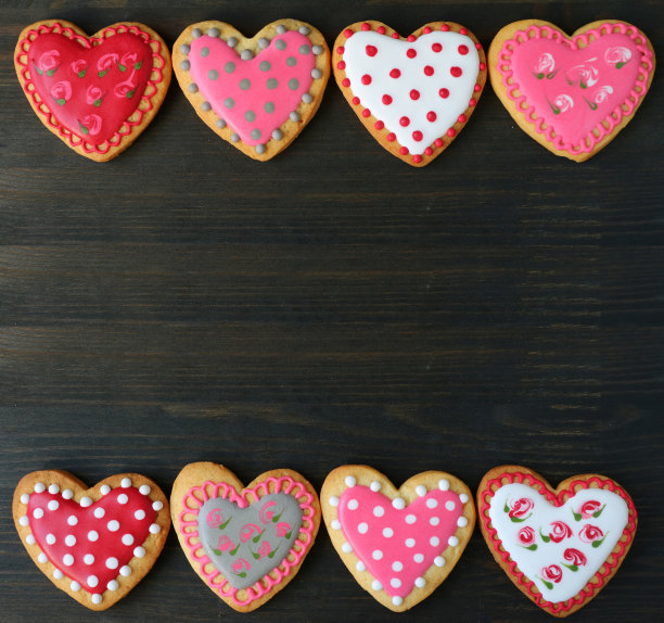 可爱的心形皇家糖衣饼干在深棕色的木制背景图片下载