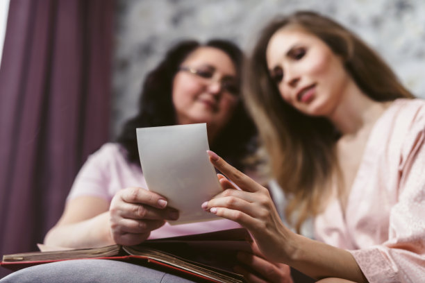 母亲和女儿正在看家庭相册或旧电影照片。周末和父母在一起，家庭日，感恩节，妈妈的节日。Self-isolation图片下载