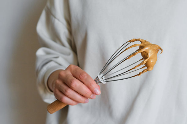 Dalgona咖啡。冷饮加冰。速溶咖啡、砂糖搅打后加入牛奶。女孩手里拿着一杯咖啡。女咖啡师制作美味的夏季饮料。专业的服务图片下载