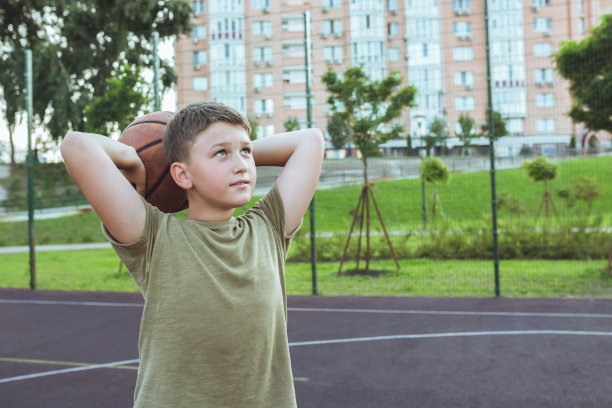 一个青少年在操场上打篮球。图片下载