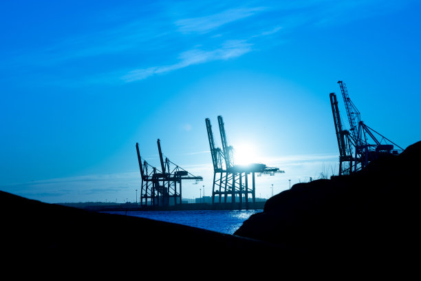 日落时分大型船舶到岸上的集装箱起重机图片下载