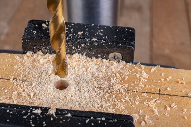 用专业工具在木材上钻孔。用台钻工作。工作车间。图片下载