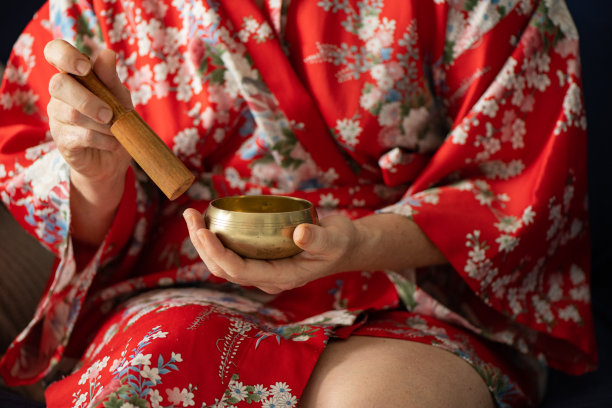 穿着长袍的女人在声音碗里冥想图片下载