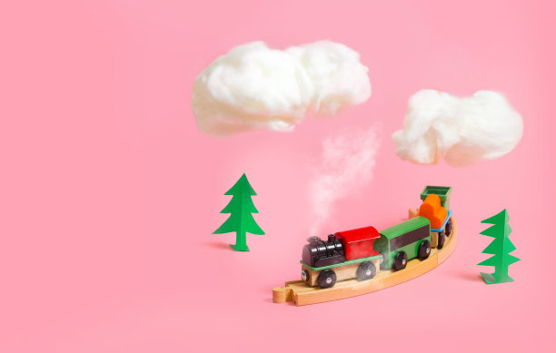 木制的彩色玩具火车与粉红色的背景细节。幼儿园和儿童游戏概念图片下载