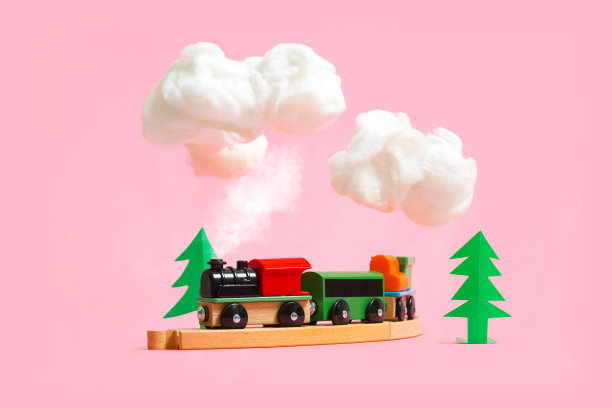 木制的彩色玩具火车与粉红色的背景细节。幼儿园和儿童游戏概念图片下载