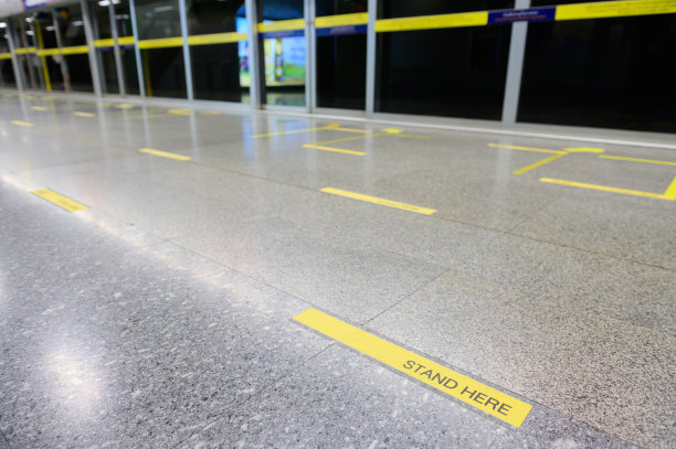 地铁站台上有一条黄线，上面写着“站在这里”，保持距离图片下载
