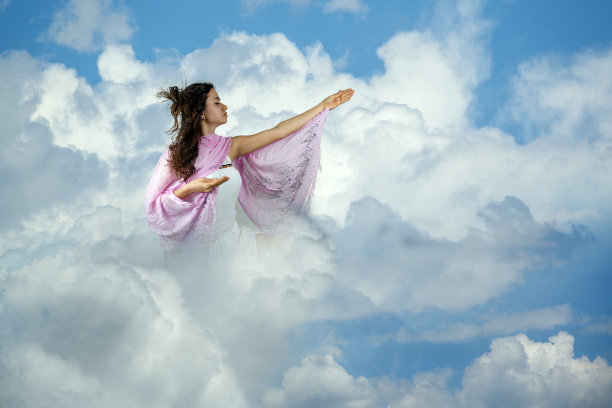年轻的女孩在云中祈祷图片下载