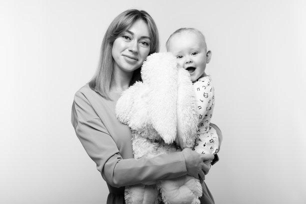 一个美丽的年轻母亲的肖像，怀里抱着一个婴儿。图片下载