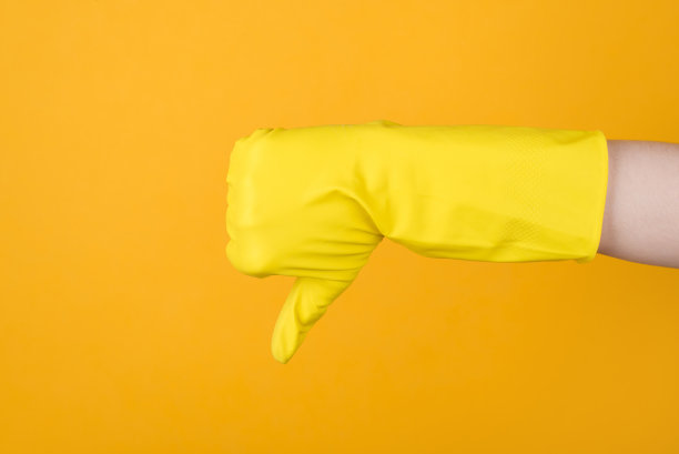管家的概念。裁剪照片的手在黄色手套显示拇指向下标志孤立在黄色背景图片下载