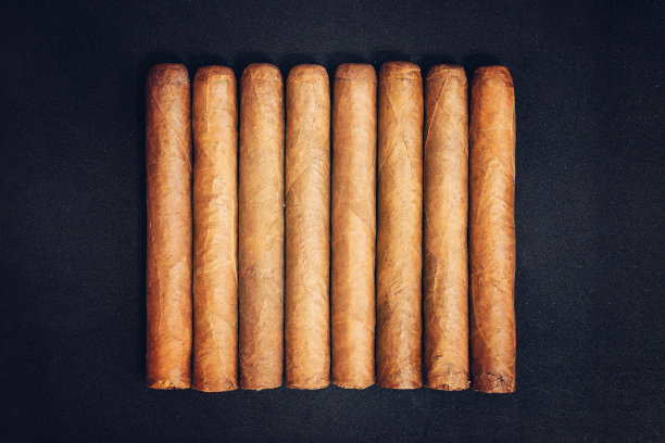 真正昂贵的古巴雪茄。黑暗中，黑桌子上放着哈瓦那雪茄图片下载