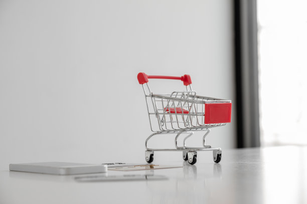 玩具、手推车、信用卡和智能手机的照片放在一张白色的桌子上图片下载