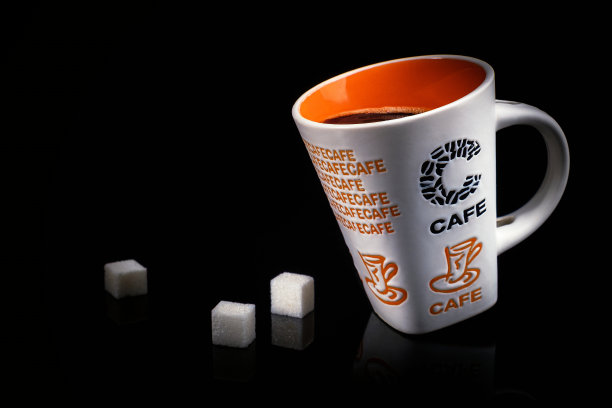 在黑色背景上放上一杯咖啡和三块方糖图片下载