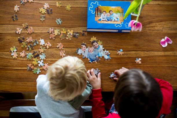 两个孩子，男孩，组装拼图与他们的图片来自秋天的森林，在家里玩图片下载