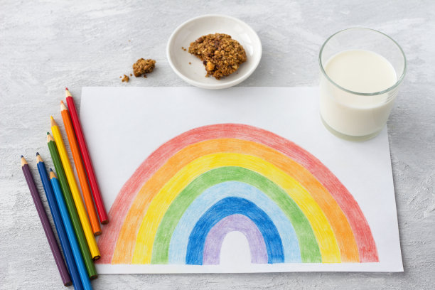 孩子们用彩虹、彩色铅笔、牛奶和巧克力饼干在浅灰色的背景上画画图片下载
