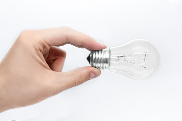 男性在白色背景上手持一个灯泡图片下载