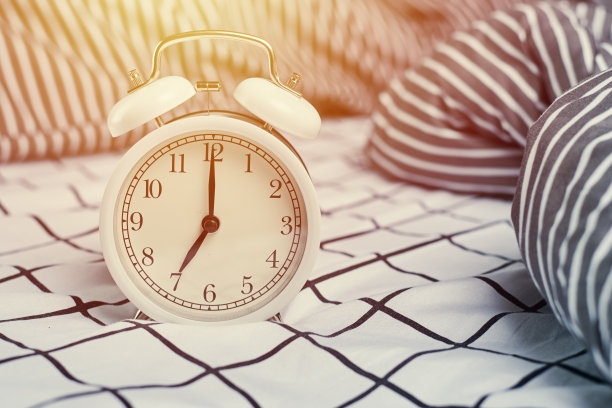 白色复古闹钟和枕头。起床和早晨的概念图片下载