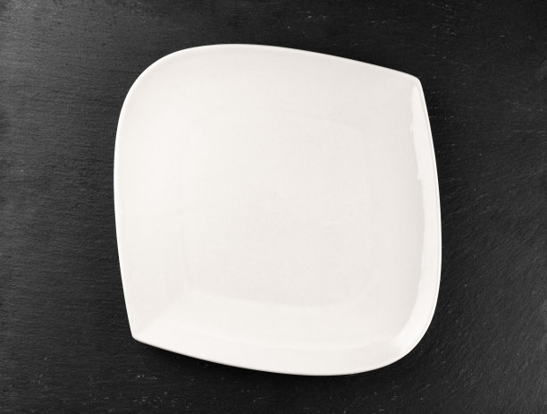 白色盘子孤立在石头上。圆空盘子为晚餐。食品的背景。餐厅厨房简约的概念。图片下载