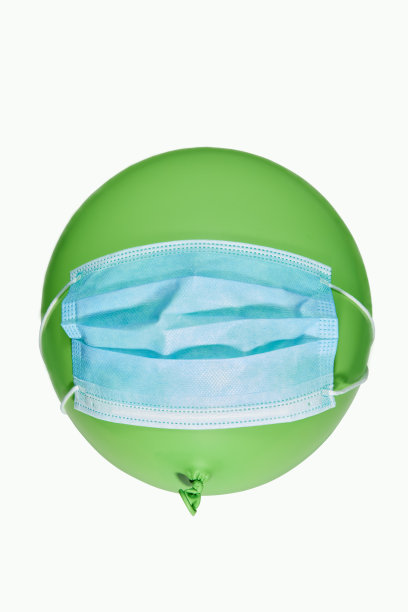 医用口罩中的绿色气球-口罩中的人的象征。预防冠状病毒病的概念。流行防护设备。图片下载