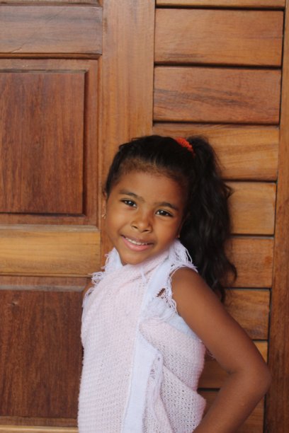 可爱小女孩的肖像。她用了你的旧木门。非裔混血儿。图片下载