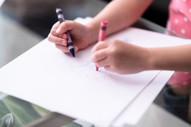 特写的学龄前女孩的手拿着两支蜡笔图片下载