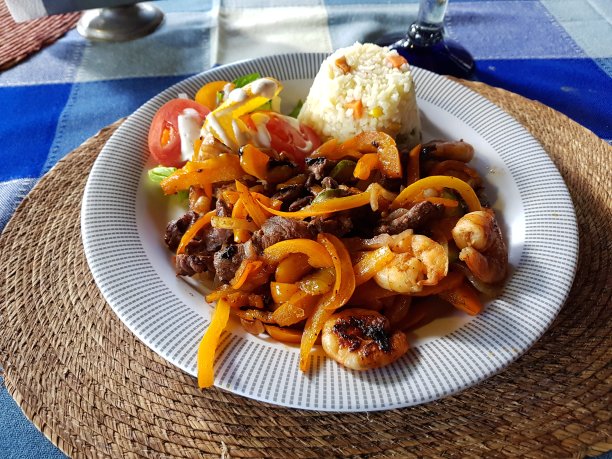 餐馆里的一道菜，有虾和牛肉，配米饭和沙拉图片下载