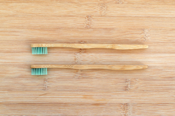 木制背景上的两个竹制牙刷。零废物，可降解材料，环保理念图片下载
