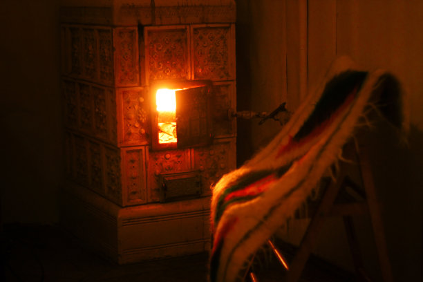 温暖的壁炉和木制的椅子，羊毛毯子，舒适的冬季假期图片下载