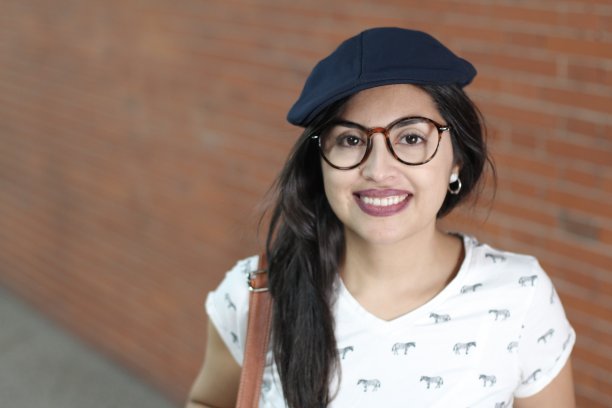 坚定的民族妇女在砖墙上微笑图片下载