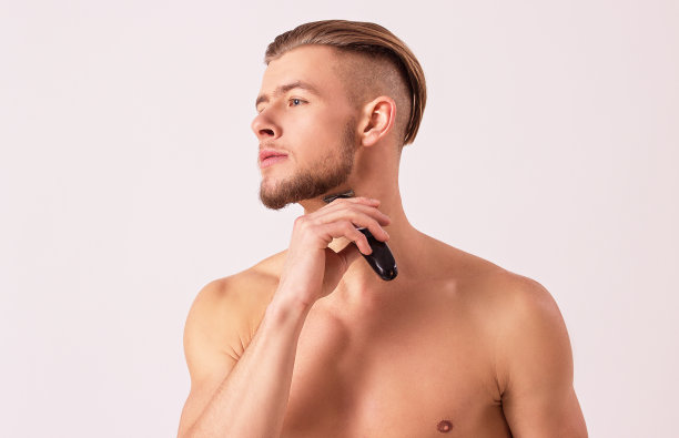英俊的男子用电动剃须刀刮脸图片下载